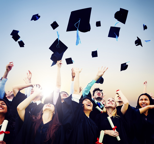 Graduates throwing mortar boards in the air