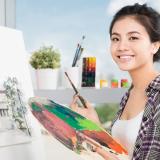 Student Artist smiling with paintbrush and paint palette